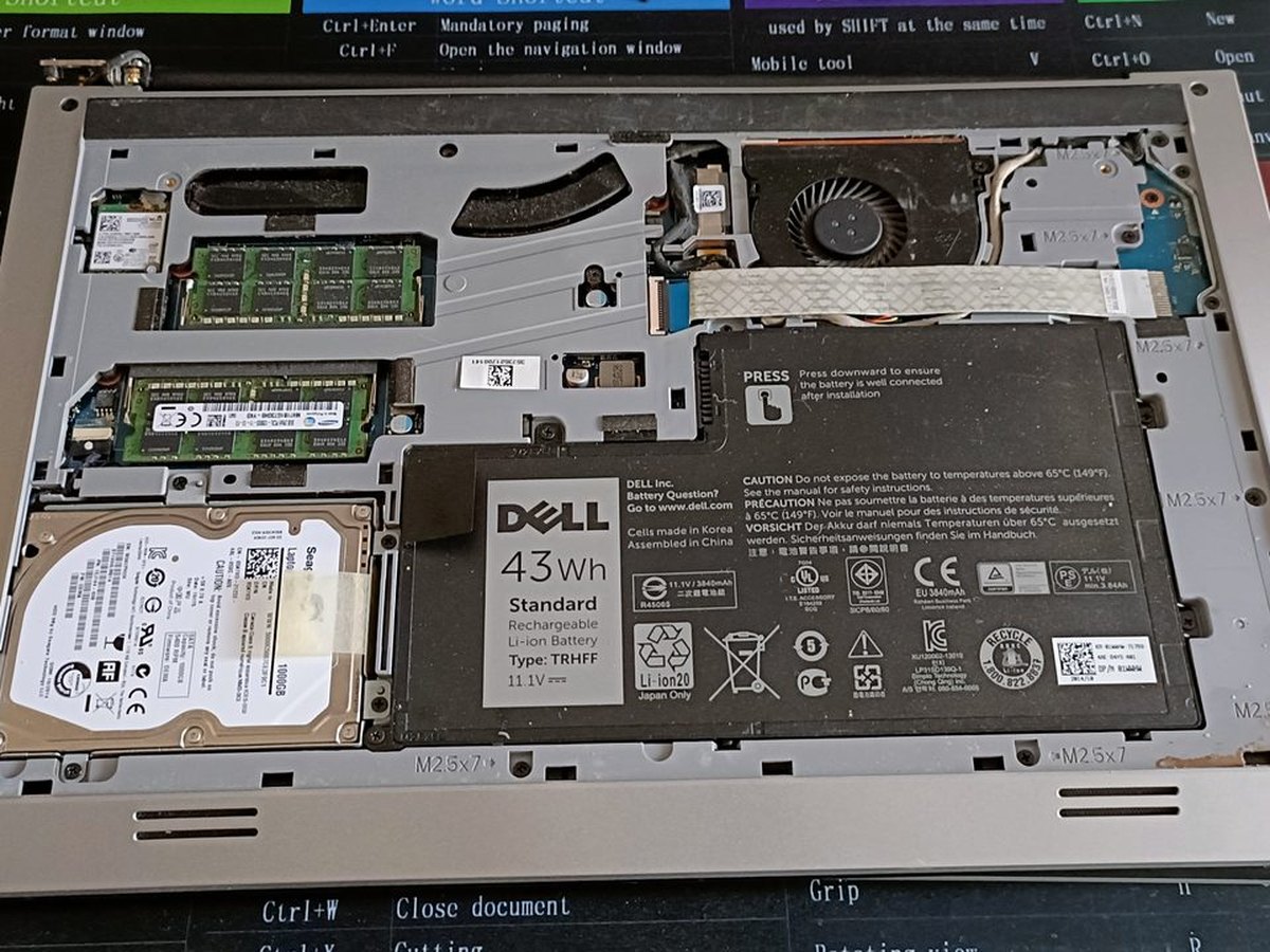 A laptop opened on the Galvitech workbench showing RAM modules, a 2.5 inch drive and a Dell battery during a repair in Paarl