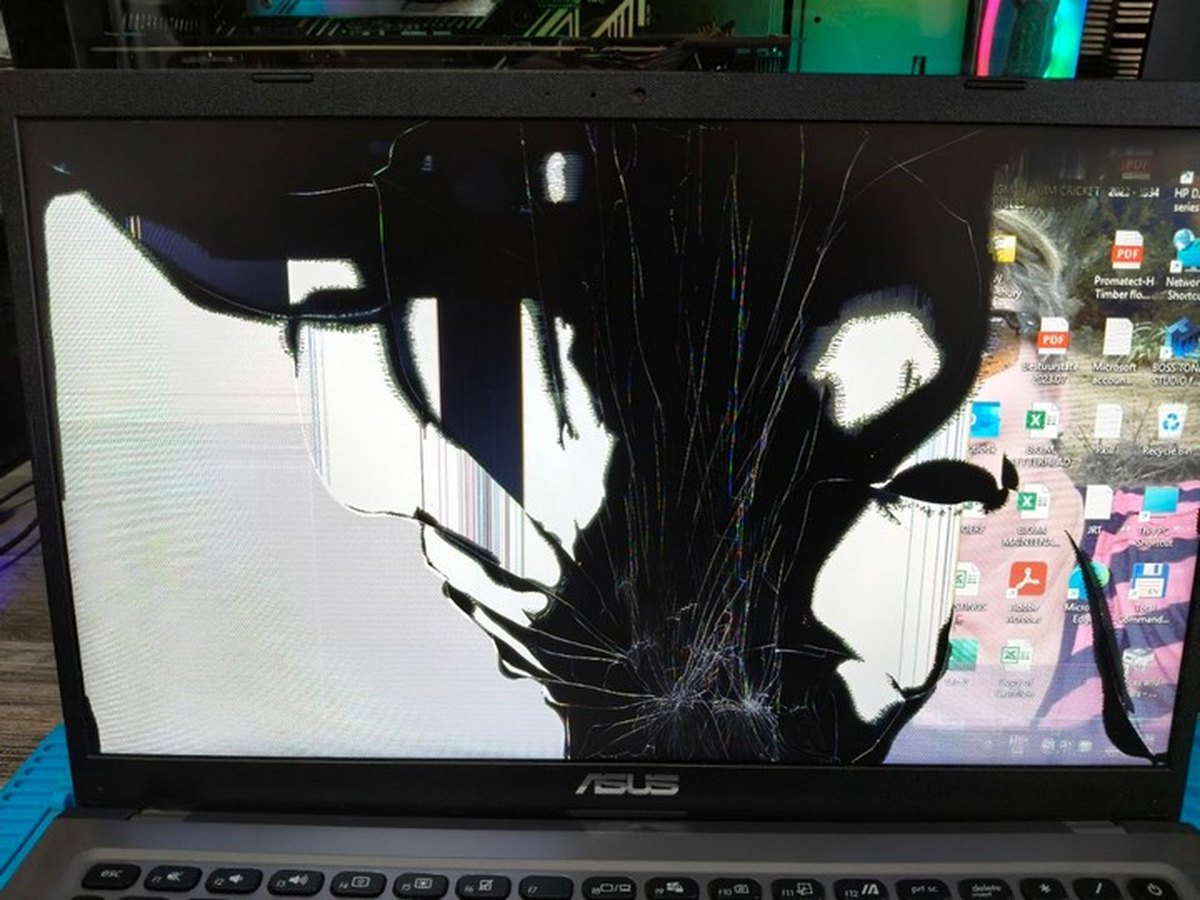 A laptop with a badly shattered screen showing impact damage across the display, awaiting repair at Galvitech in Paarl
