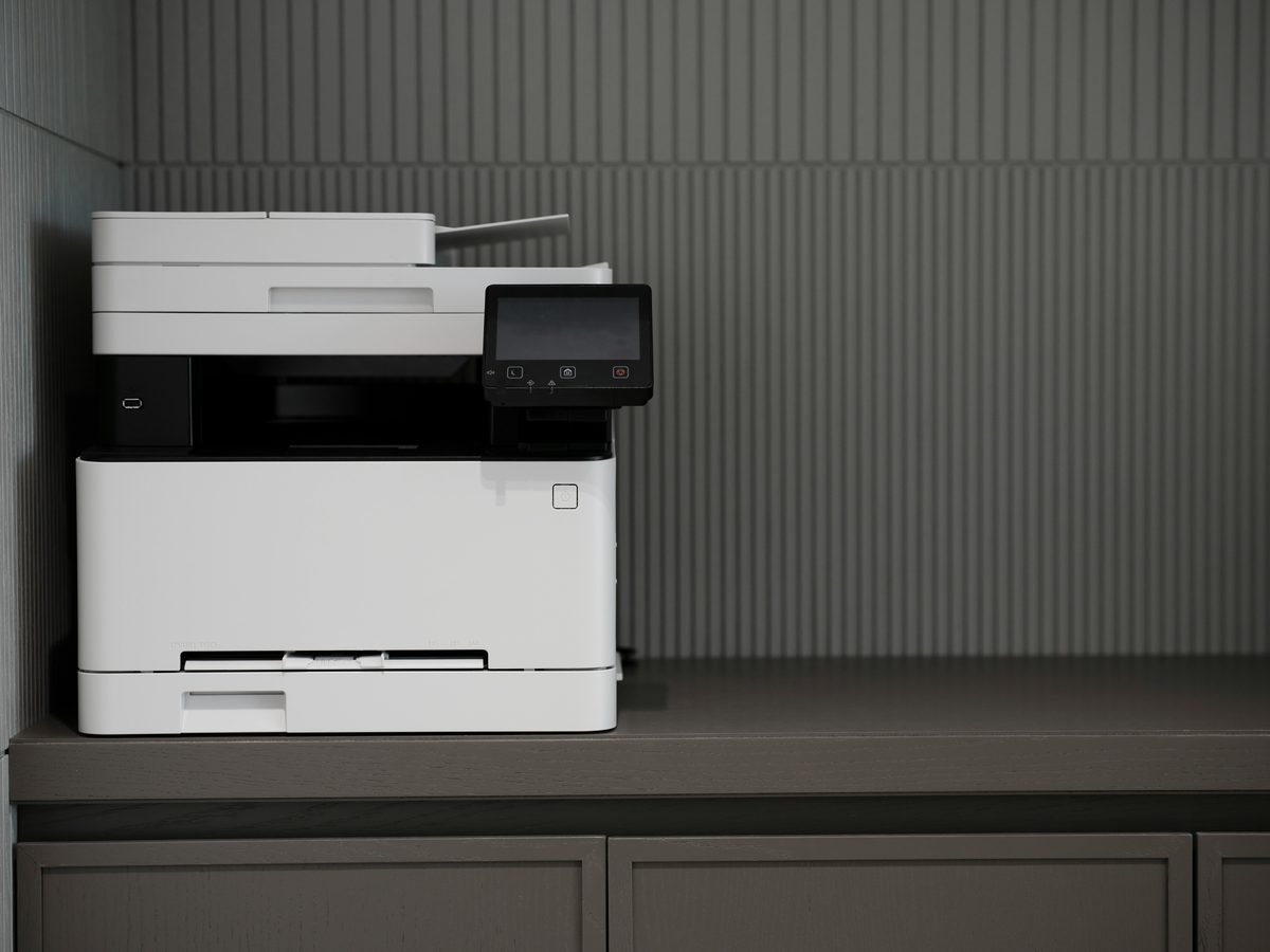 A stack of office printers on a desk, illustrating the printer repair service